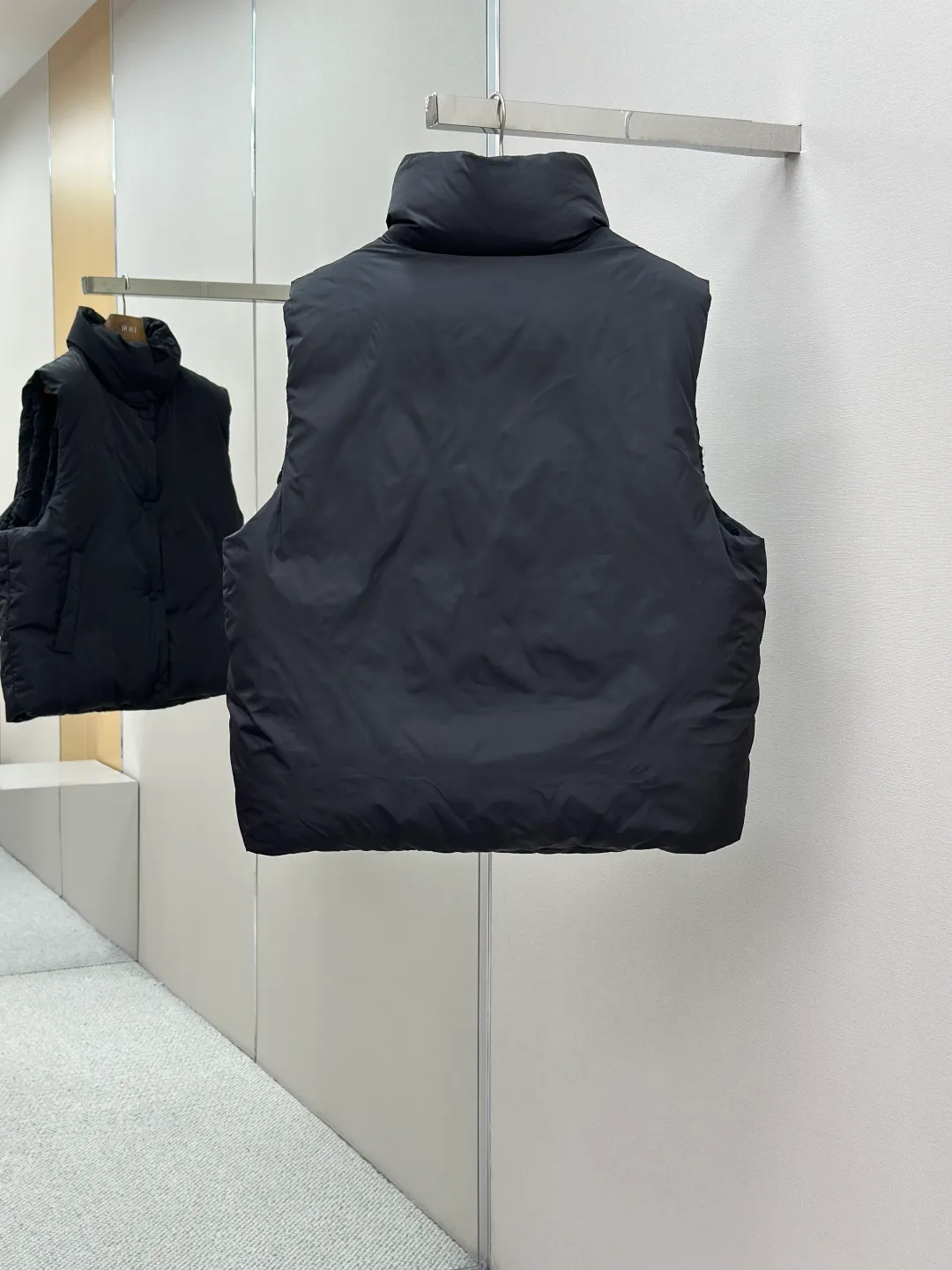 P810 AMIPARIS love padded embroidered down vest Fabric selection: Taffeta fabric woven from 100% polyester fiber. It adopts warp and weft plain weave and is woven very tightly, making the surface of the fabric extremely smooth and flat, with a "skinny" and stiffness that is not easy to collapse. When rubbed or moved around, it will make a unique, crisp "rustling" sound. At the same time, it has a delicate plain texture and a soft, elegant silky luster. This kind of luster is not as dazzling as satin, but more restrained and advanced.  Lining selection: Use 100% nylon to create the lining. The high-density and tight weaving process prevents tiny lint from getting out of the gaps in the fabric. The smooth surface improves the putting on and taking off experience, and the excellent wear and tear resistance ensures damage caused by frequent use, while the light and soft texture does not affect the overall weight.  Technology: The fabric and padding material are tightly fixed on the frame of the embroidery machine. The embroidery machine uses sparse stitches along the padding layer to outline the filling area of the pattern, and then runs the overlay layer's padding, using dense stitches to perfectly cover the foam padding layer, thus forming a slightly raised love embroidery, which feels soft and full, enhancing recognition while maintaining a low profile. High-quality filling: It uses 90 white duck down with a weight of 160g to ensure excellent thermal insulation performance. After strict screening and processing, the velvet is not easy to get drilled, ensuring durability.  Accessories: One-to-one customized three-standard, one-to-one customized hem elastic buckle, one-to-one customized snap button SIZE: XS S M L